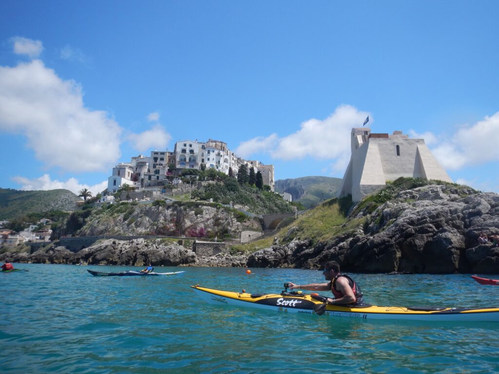 Vista dal mare di canoe in gita a Sperlonga sullo sfondo